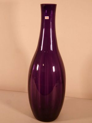 a purple glass vase sitting on a white surface