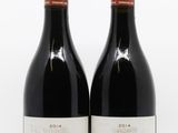deux bouteilles de vin rouge posées l'une à côté de l'autre sur une surface blanche