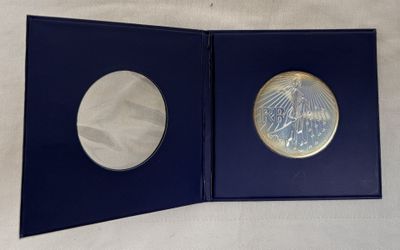 un gros plan d'une boîte bleue contenant une pièce d'argent