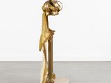 gold statue of a woman with a hat on her head
