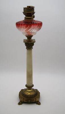une photo d'une lampe de table en verre rouge et blanc posée sur un pied