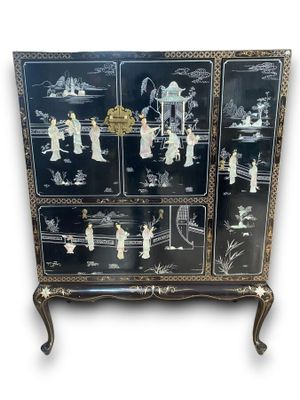 Un cabinet en bois laqué noir à décor figurant des personnag…