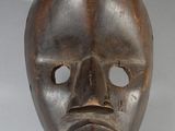 an image of a wooden mask on a white surface