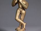 an image of a gold statue of a man playing a flute