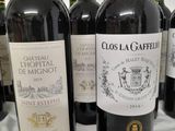 several bottles of red wine are lined up on a table