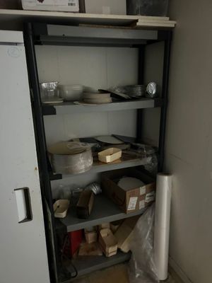 un réfrigérateur et des étagères dans une cuisine où sont posés de la vaisselle