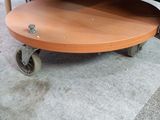 a wooden table that is on wheels in a room