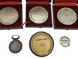 three medals and a keychain are sitting in a wooden box