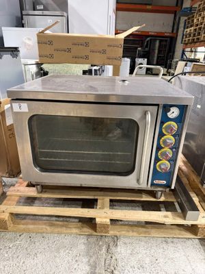 a small oven sitting on a pallet in a warehouse