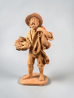 statue d'un garçon portant un panier de fruits sur l'épaule