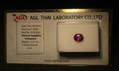un gros plan d'un diamant rose sur une carte blanche