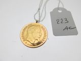 une pièce d'or à laquelle est attachée une étiquette de prix