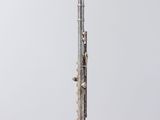 a silver flute sitting on top of a white pedestal