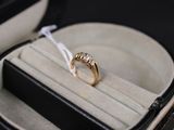 une bague en or dans un écrin noir orné d'un ruban blanc