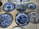 many blue and white plates and bowls on the table