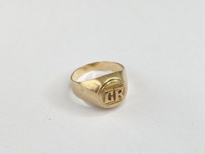 a close up of a gold signet ring on a white surface