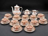 many cups and saucers and a teapot on the table