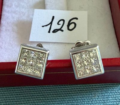 deux paires de boucles d'oreilles en diamant dans un coffret rouge avec une étiquette de prix