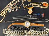several pieces of jewelry including a watch, bracelets, and necklaces