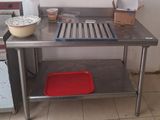 une cuisine avec une table en inox et un plateau rouge