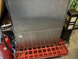 a silver dishwasher sitting on a red rack in a garage