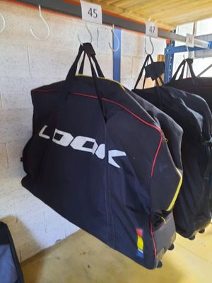 de nombreux sacs suspendus à un porte-sacs dans un garage