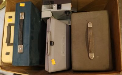 several pieces of luggage sitting in a cardboard box on a table