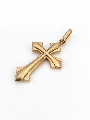 un gros plan d'un pendentif en forme de croix dorée sur fond blanc