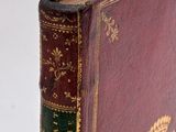 an old book sitting on top of a white table next to a white wall