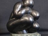 sculpture of three hands holding each other on a green marble base