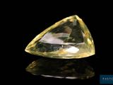 a close up of a yellow diamond on a black surface