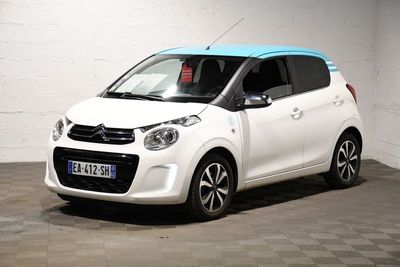 La petite voiture blanche est garée dans le garage.