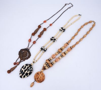 a group of three necklaces on a white surface