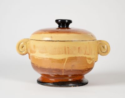 pot en céramique jaune et marron avec des anses sur un fond blanc
