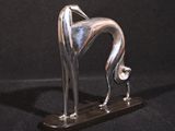 sculpture en argent représentant un lévrier sur fond noir