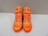 an orange pair of shoes with orange laces on them on a white surface