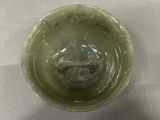 a glass with a green substance in it sitting on a table