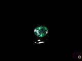 a close up of a green emerald stone on a black background