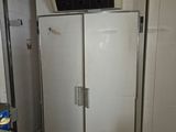an image of a refrigerator in a kitchen with a microwave on top of it