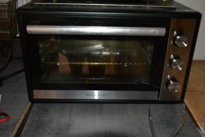 un four grille-pain posé par terre dans la cuisine
