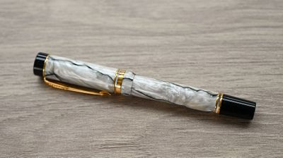 a pen that is laying on a wooden table