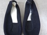 pair of black shoes with white soles sitting on a gray surface