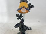 une lampe ornée d'un oiseau, posée sur une table