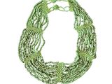 a close up of a green necklace on a white background