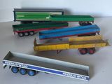 Plusieurs camions miniatures sont alignés sur une surface blanche