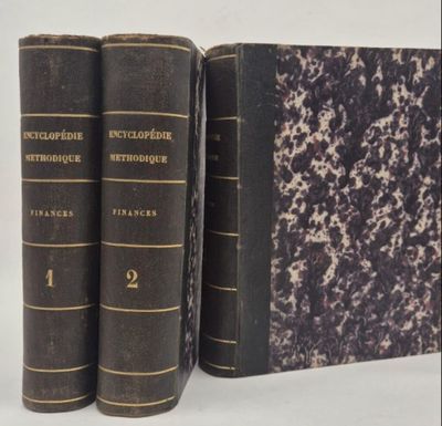 three old books sitting on top of each other on a white surface