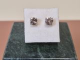 a pair of earrings sitting on top of a marble block