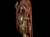 an old wooden statue of a man holding a bird