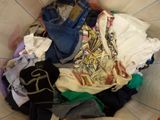 a basket full of clothes that is sitting on a bed