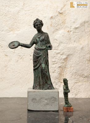 une statue représentant une femme tenant un frisbee, à côté d'une petite statue représentant un homme